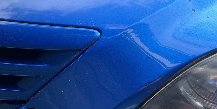 Originally dented blue car with dent removed